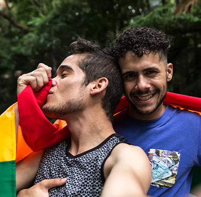two men with rainbow flag wrapped around them