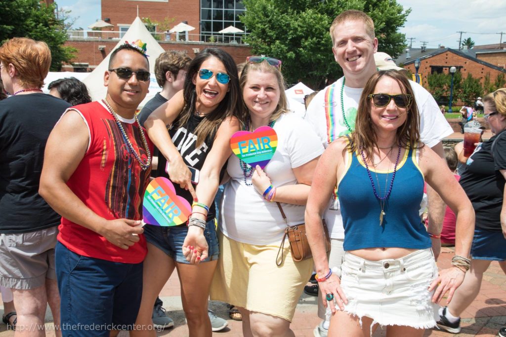group of friends holding rainbow heart Chris Fair fans