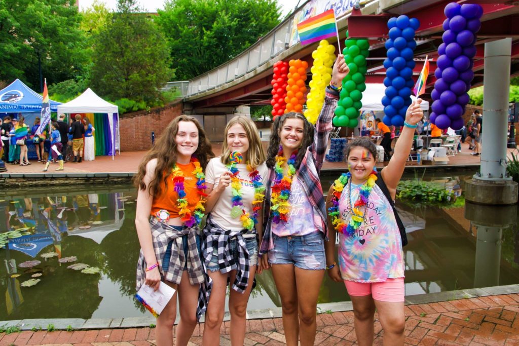 group of friends wearing rainbow leis and posing