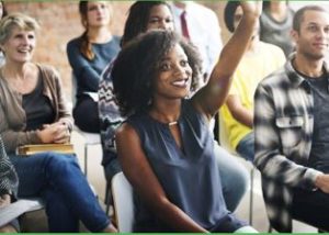 woman sitting in group raising her hand