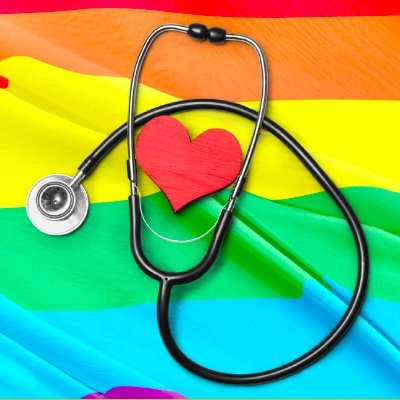 stethoscope laying on rainbow flag with heart resting in center