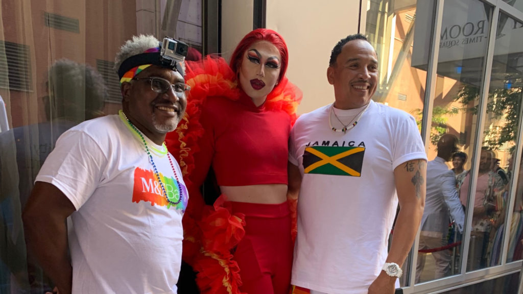 wil graham posing next to drag queen wearing all red